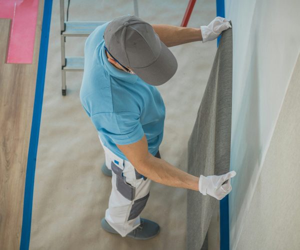 Caucasian Worker Applying Vinyl Wallpaper